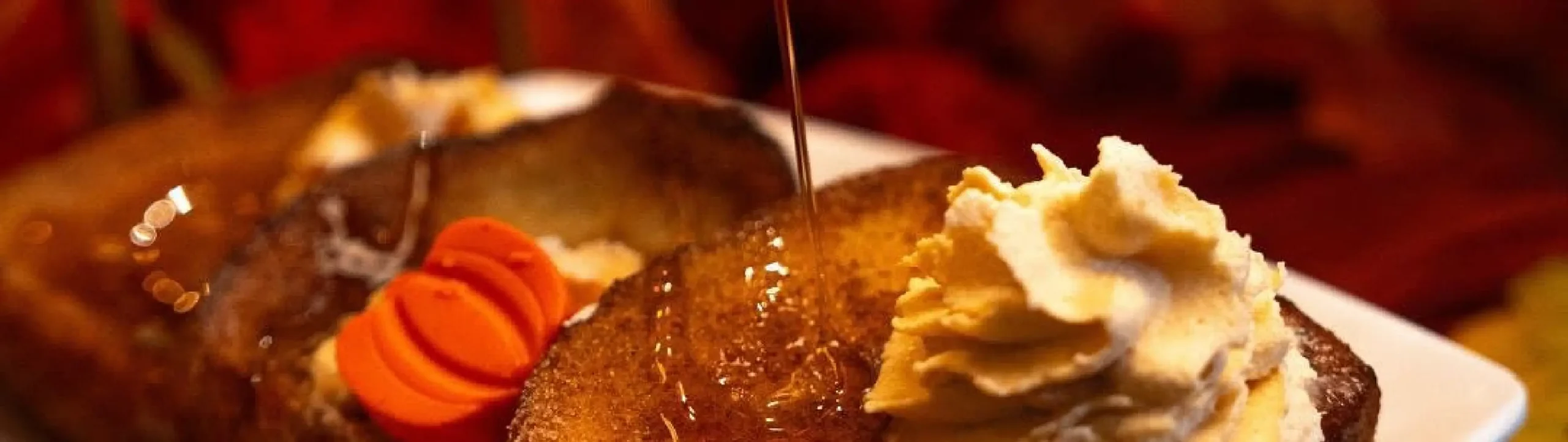 Freshly made French toast topped with whipped cream and maple syrup drizzle at Rosallie Café in Las Vegas
