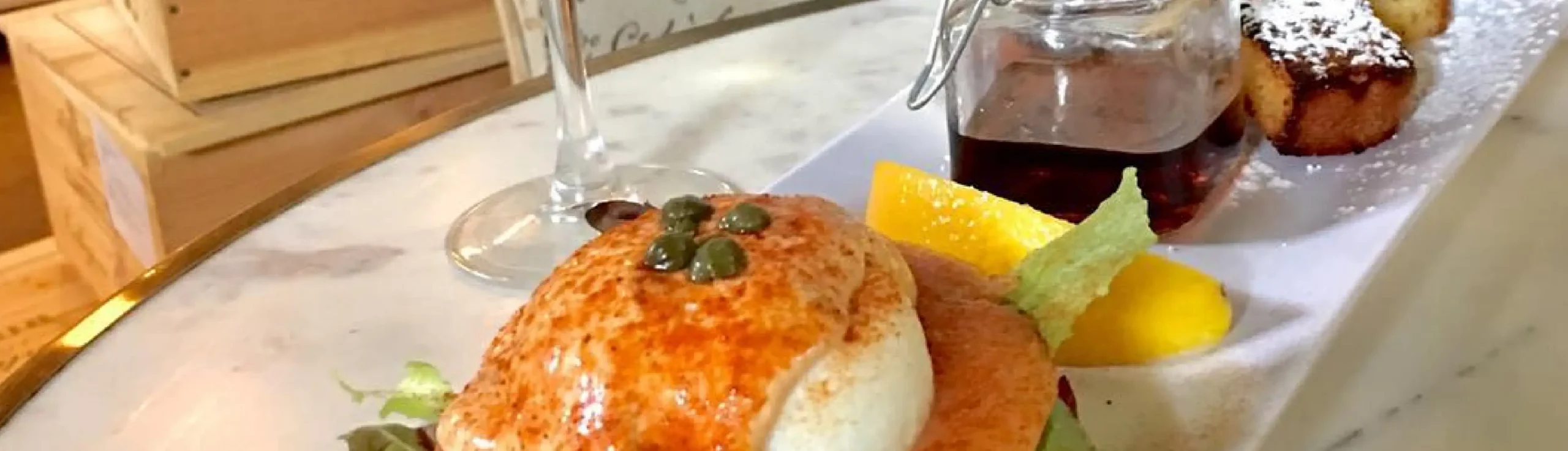 Smoked salmon eggs Benedict served with salad, syrup, and French toast at Rosallie Café brunch